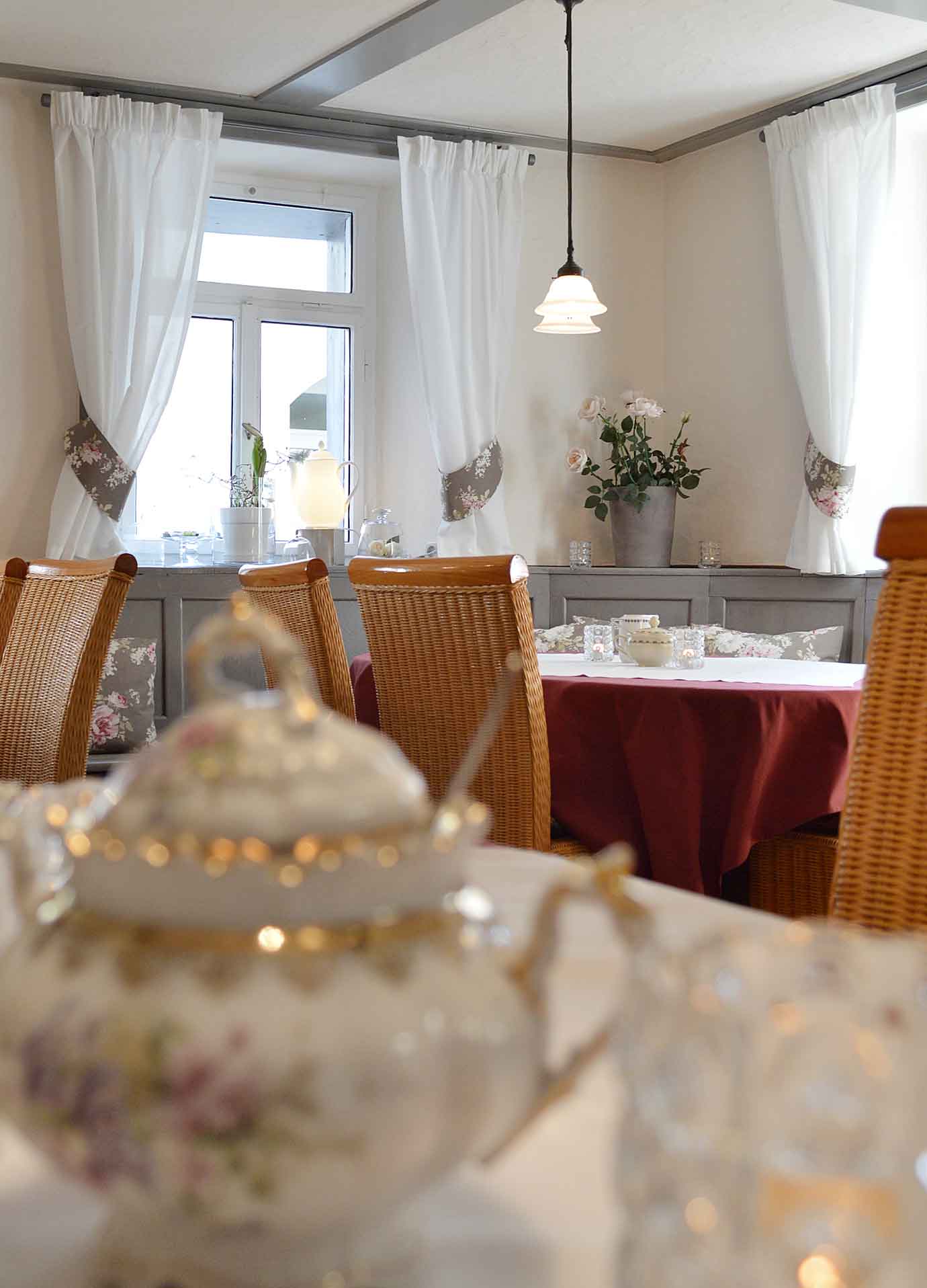 Innenaufnahme des Cafés: zarte Farben von Rosa und Grau in Kombination mit Rosenmustern Innenaufnahme des Cafés: zarte Farben von Rosa und Grau in Kombination mit Rosenmustern