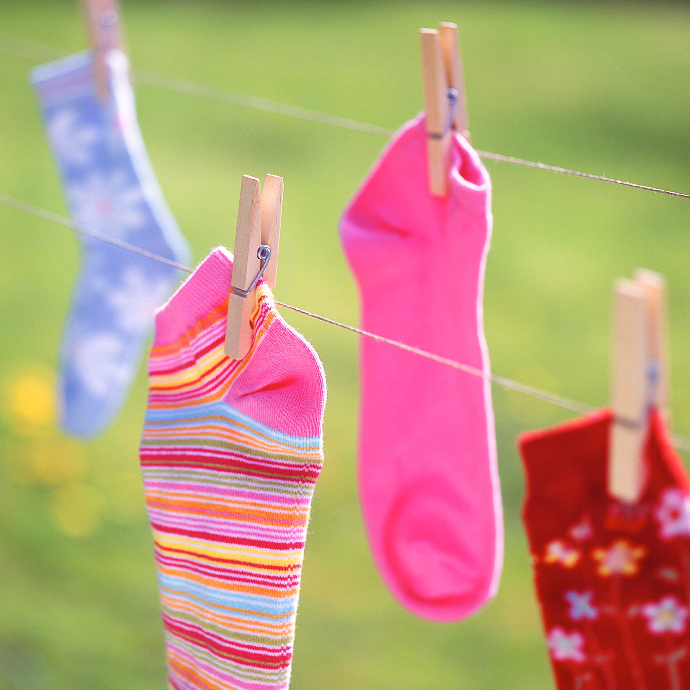 Bunte Kindersocken hängen an der Wäschleine