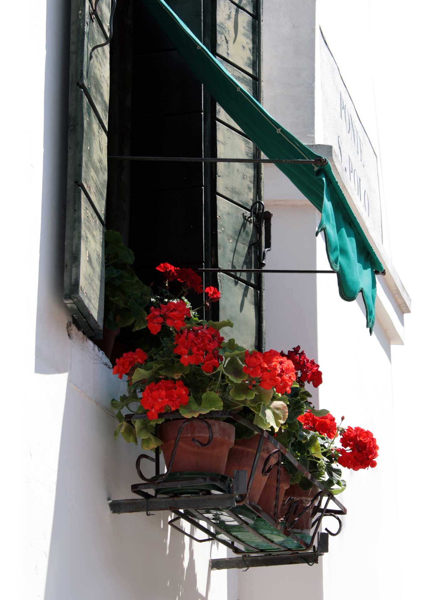 Fenster mit roten Geranien in Venedig
